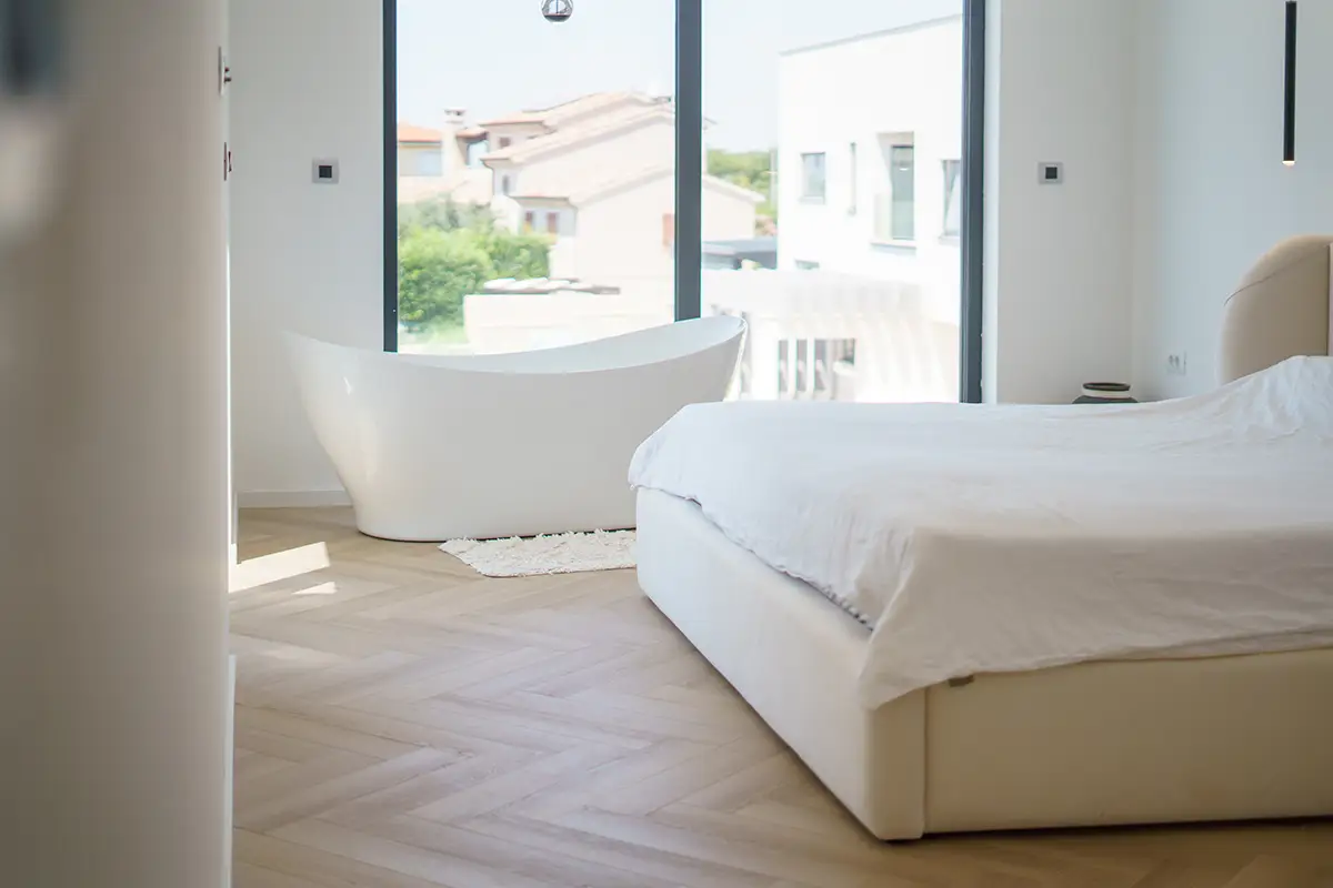 Svetlá spálňa s elegantnou drevenou podlahou, ktorá zvýrazňuje teplo a prirodzenú estetiku priestoru